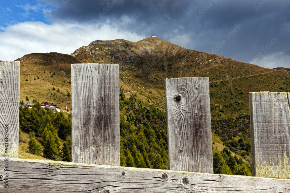 A wooden fence in front of the Carnic Alps with a dramatic sky, Alps, South Tyrol, Italy, Europe