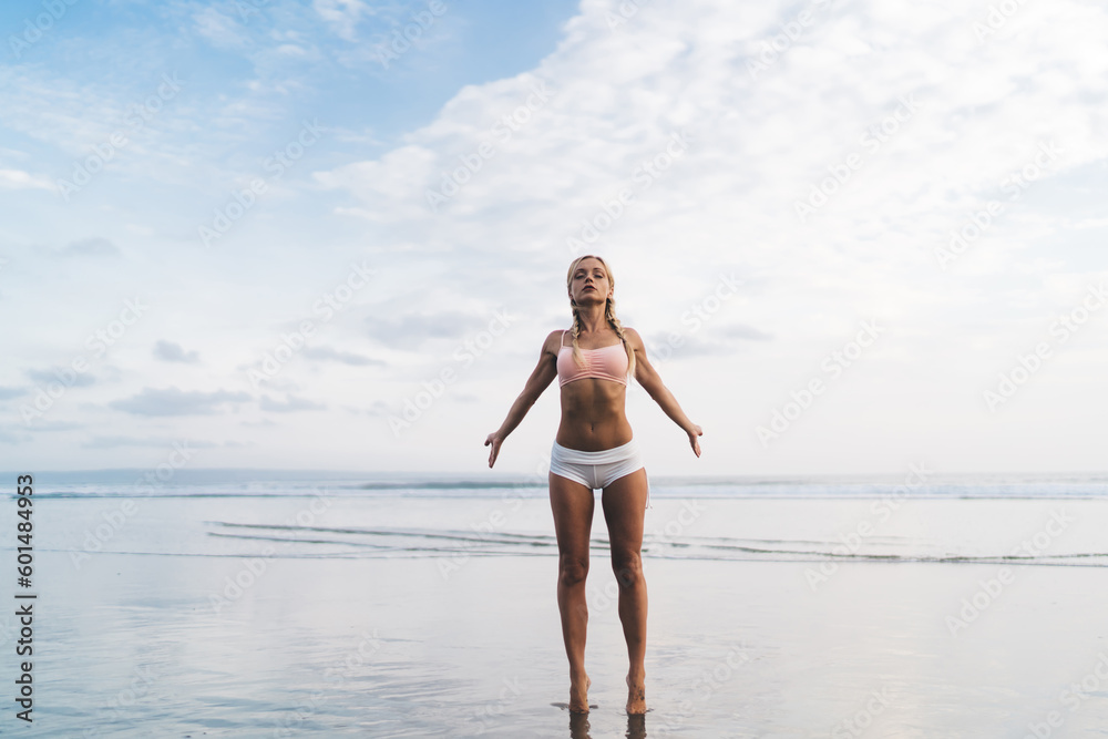 Calm fit girl with closed eyes feeling enlightenment freedom while spending summertime for yoga stretching at seaside on sandy beach, attractive Caucasian woman enjoying healthy lifestyle and healing Calm fit girl with closed eyes feeling enlightenment freedom while spending summertime for yoga stretching at seaside on sandy beach, attractive Caucasian woman enjoying healthy lifestyle and healing