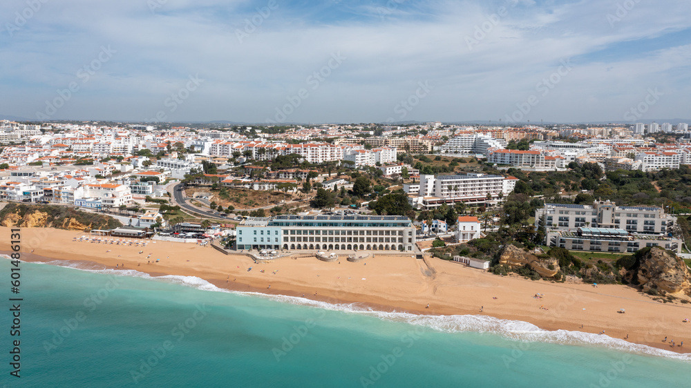Aerial photo of the beautiful town in Albufeira in Portugal showing the Praia de Albufeira golden sandy beach, with hotels and apartments in the town, taken on a summers day in the summer time.