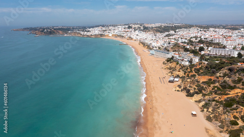 Aerial photo of the beautiful town in Albufeira in Portugal showing the Praia de Albufeira golden sandy beach, with hotels and apartments in the town, taken on a summers day in the summer time. © Duncan