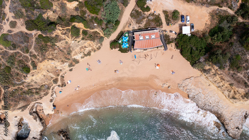 Obraz na płótnie Straight down aerial photo of the beautiful town in Albufeira in Portugal showing the Praia dos Aveiros beach with and people relaxing on vacation on the beach on a hot summers day in the summer. w salonie