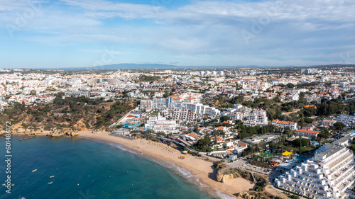 Aerial photo of the beautiful town in Albufeira in Portugal showing the Praia da Oura golden sandy beach, with hotels and apartment in the town, taken on a summers day in the summer time. © Duncan