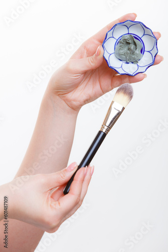 Woman mixing face mask in little porcelain bowl