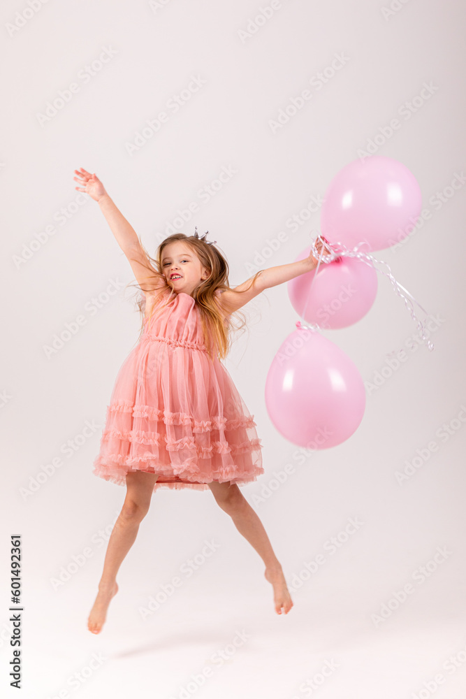 People, joy, fun and happiness concept. Relaxed happy birthday little girl celebrating cheerful, smiling happily, posing for picture, holding colorful helium balloons