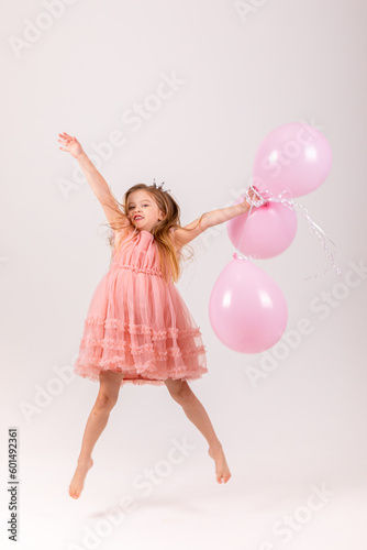 People, joy, fun and happiness concept. Relaxed happy birthday little girl celebrating cheerful, smiling happily, posing for picture, holding colorful helium balloons © Irina Mikhailichenko