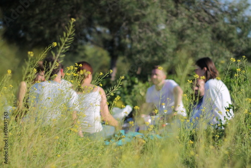A Day in the Field Amongst Yellow Flowers: Young Adults Enjoying a Picnic in a Relaxed and Natural Setting