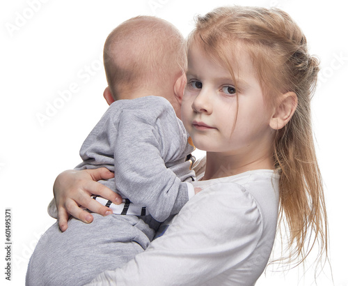 Photography The child is holding a baby in her arms, the concept of a mother's assistant