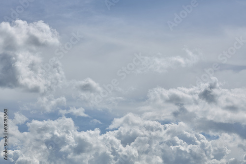 Cumulus clouds against a light blue sky with a clear fiber structure. © justoomm