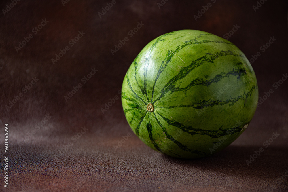 Whole watermelon on the dark brown background Whole watermelon on the dark brown background