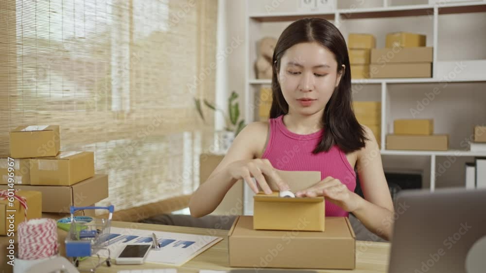 Pack products, Woman packing goods into a postal box, Online Shopping, Freelance working, Sell products online. Pack products, Woman packing goods into a postal box, Online Shopping, Freelance working, Sell products online.
