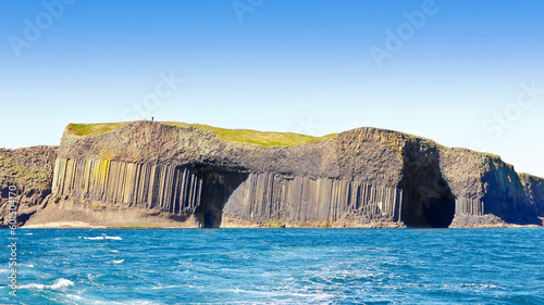 Foto Tourists walking on the famous island of Staffa, consisting of dark hexagonal basalt columns, Inner Hebrides, Scotland
