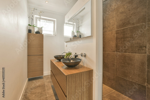 a bathroom with a sink, mirror and wooden cabinet in the corner next to the bathtub on the wall