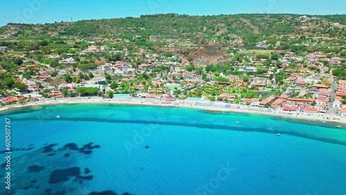 Aerial view of people relaxing at Spiaggia di Grotticelle beach with blue sea. Tourists enjoy a vacation on a summer day at Capo Vaticano, Province of Vibo Valentia, Italy. photo