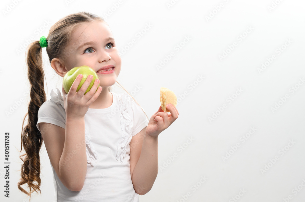 Green apple and potato chips, healthy and unhealthy food for kids, little girl chooses apple over chips. Green apple and potato chips, healthy and unhealthy food for kids, little girl chooses apple over chips.