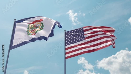 West Virginia flag and the USA flag on a flagpole realistic wave on strong wind in blue sky. State of West Virginia and The United States of America