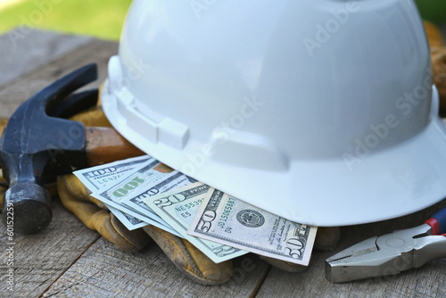 Hard hat with construction tools and cash money - concept for building cost or fraud, scam, bribes