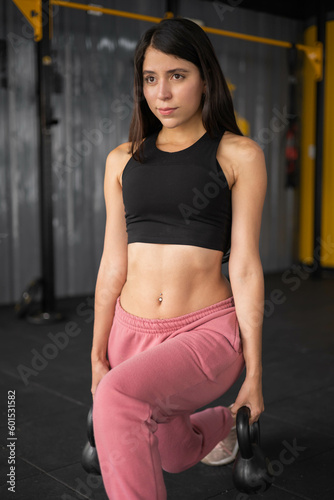 details of exercise routine, equipment for strength, weights in the gym a beautiful slim latin woman in sportswear, physical activity and lifestyle