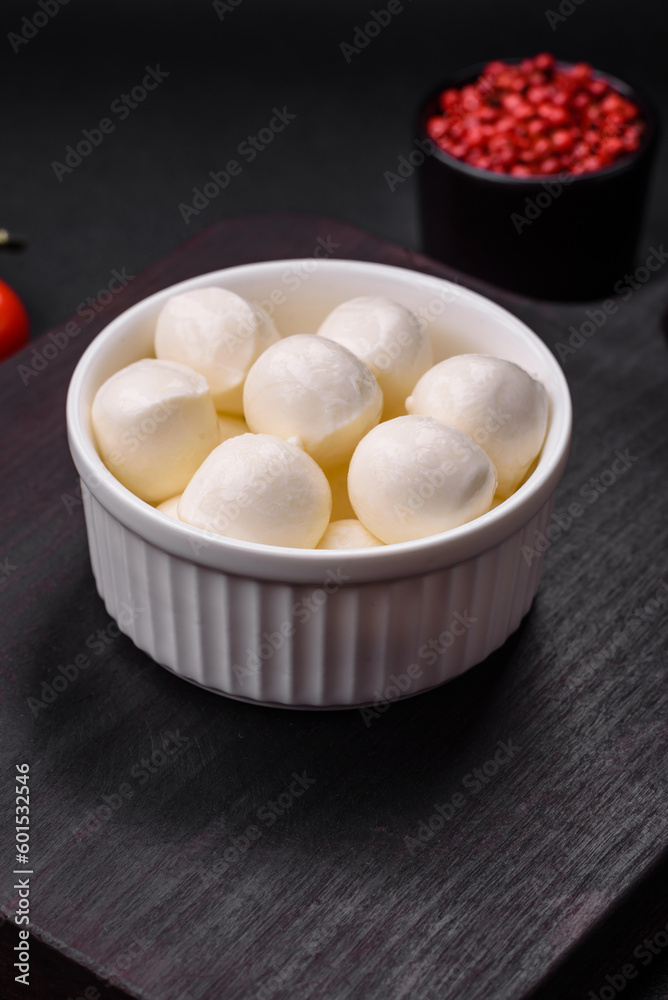 Delicious fresh mozzarella cheese in the form of small balls with salt and spices Delicious fresh mozzarella cheese in the form of small balls with salt and spices
