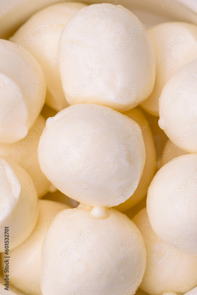 Delicious fresh mozzarella cheese in the form of small balls with salt and spices Delicious fresh mozzarella cheese in the form of small balls with salt and spices