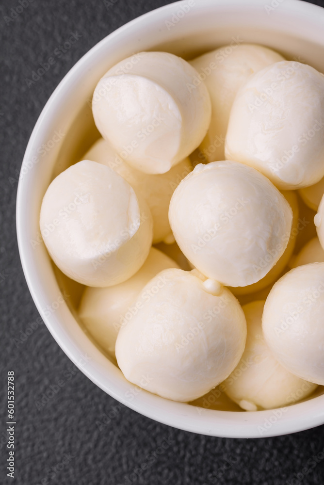 Delicious fresh mozzarella cheese in the form of small balls with salt and spices Delicious fresh mozzarella cheese in the form of small balls with salt and spices