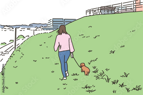 屋外で犬と散歩する若い女性
