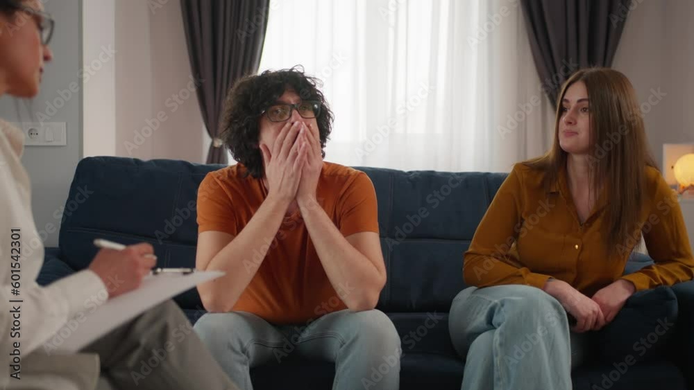 Unhappy couple argues and expresses their relationship problems during a therapy session with psychologist. Marital therapy. Resolving relationship issues Unhappy couple argues and expresses their relationship problems during a therapy session with psychologist. Marital therapy. Resolving relationship issues