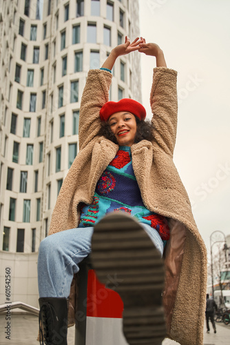 Excited multiracial lady posing camera in city and looking with happy smile