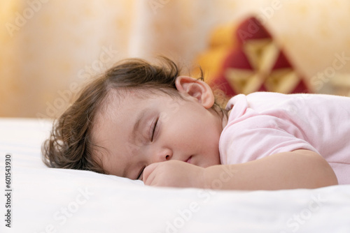 Photographie Healthy little baby girl infant wearing pink cloth sleeping calm peaceful relax on white bed at home