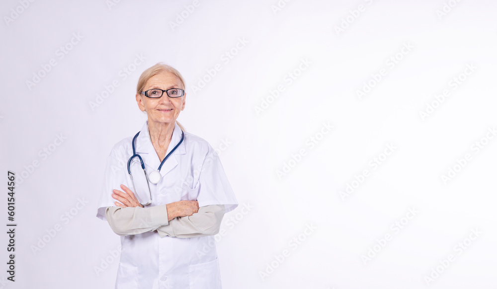 Confidence senior elderly woman wear uniform doctor coat eyeglasses standing arms crossed over isolated white background. Cheerful older woman stethoscope doctor smiling looking camera health care. Confidence senior elderly woman wear uniform doctor coat eyeglasses standing arms crossed over isolated white background. Cheerful older woman stethoscope doctor smiling looking camera health care.