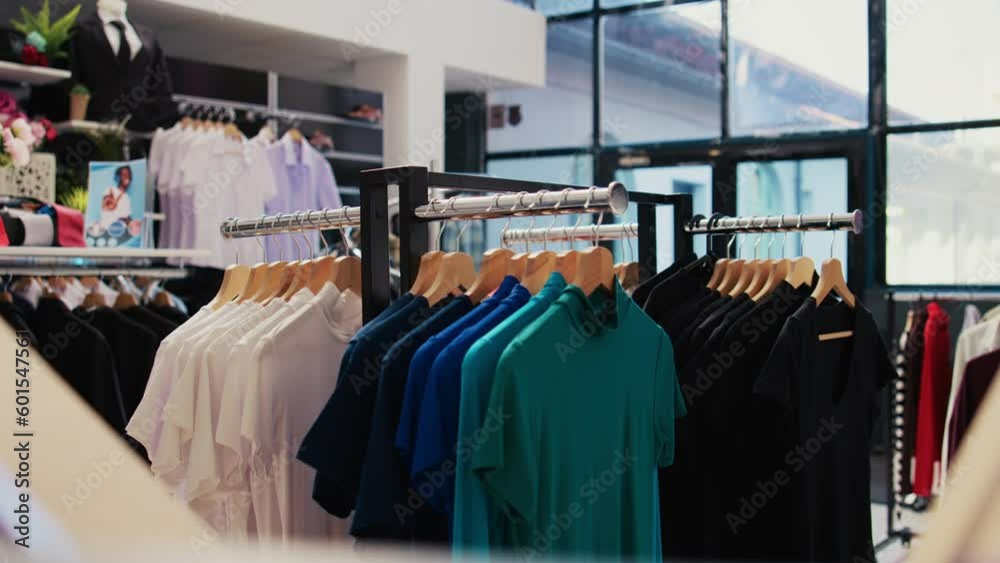Selective focus of racks full with colorful shirt in empty modern boutique, filled with formal and casual wear design. Fashionable clothes on discount, small business commercial activity. Selective focus of racks full with colorful shirt in empty modern boutique, filled with formal and casual wear design. Fashionable clothes on discount, small business commercial activity.