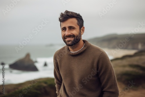 Portrait of a handsome young man at the beach on an autumn day