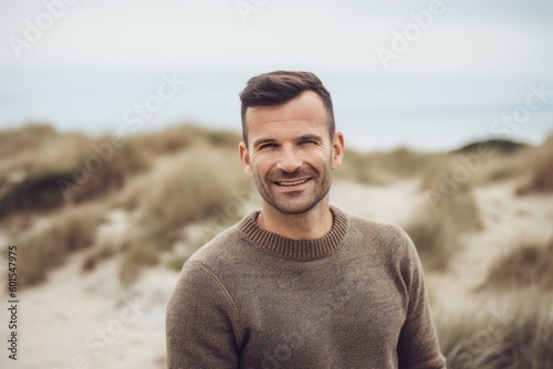 Portrait of handsome man standing on the beach, looking at camera