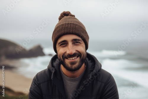 Portrait of a smiling young man standing on the beach in winter © Hanne Bauer