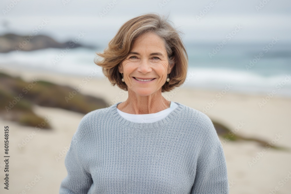 Portrait of smiling senior woman standing on beach at the day time Portrait of smiling senior woman standing on beach at the day time