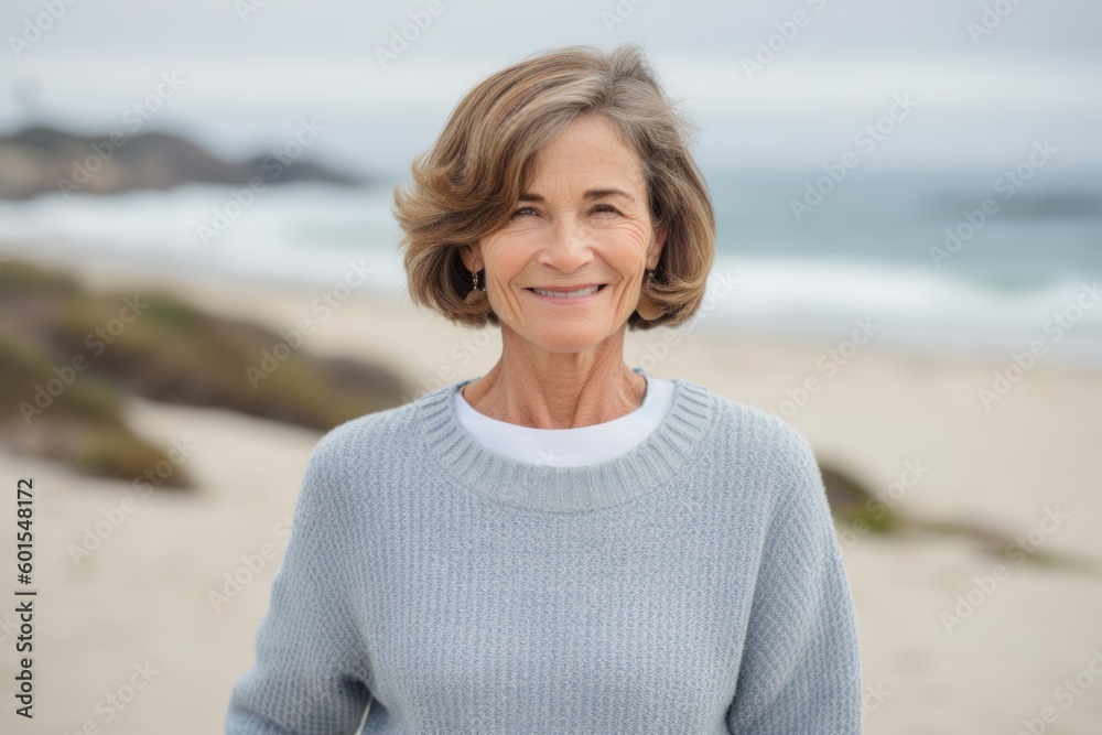 Portrait of smiling senior woman standing on beach at the day time Portrait of smiling senior woman standing on beach at the day time