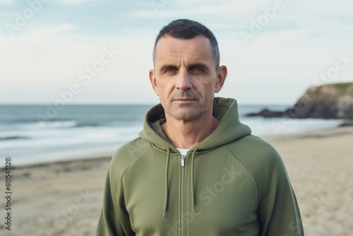 Portrait of middle aged man looking at camera while standing on beach