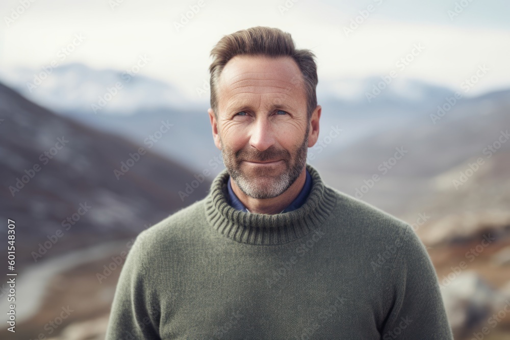 Portrait of smiling middle-aged man standing outdoors against snowy mountains