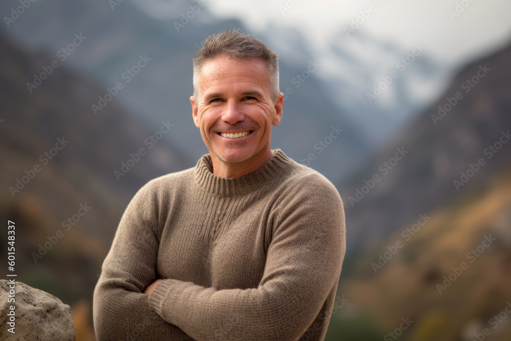 Portrait of a smiling middle-aged man standing in the mountains Portrait of a smiling middle-aged man standing in the mountains