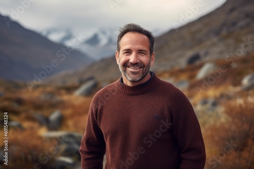 Portrait of a handsome smiling man in the mountains during autumn time