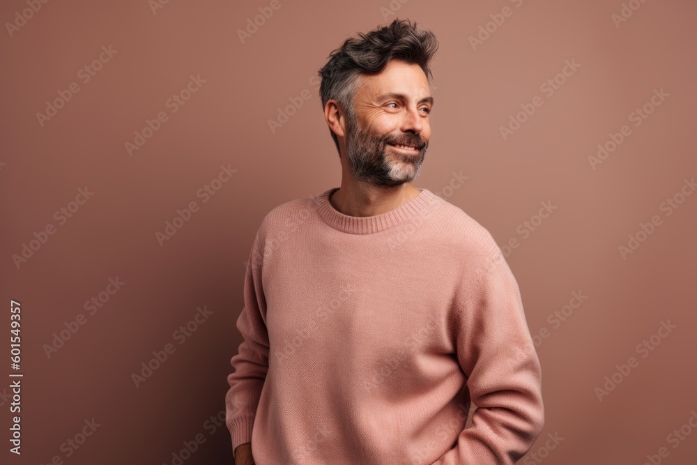 Portrait of a handsome middle-aged man in a pink sweater on a brown background Portrait of a handsome middle-aged man in a pink sweater on a brown background