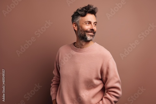 Portrait of a handsome middle-aged man in a pink sweater on a brown background
