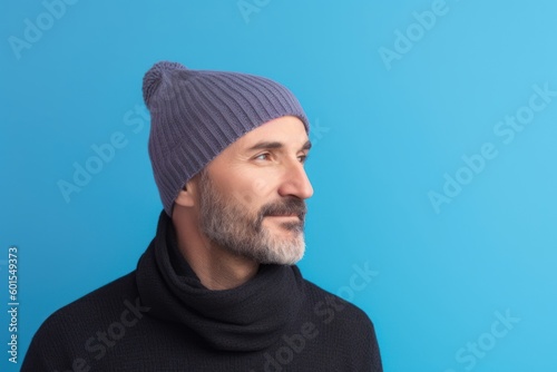 Portrait of a man in a hat and sweater on a blue background