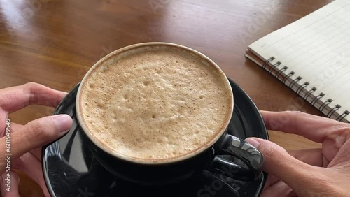 shaking and jiggle coffee foam on black cup. cute and delicious coffee foam