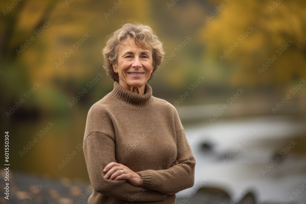 Portrait of a senior woman standing by the river in autumn. Portrait of a senior woman standing by the river in autumn.