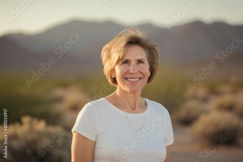 Portrait of a smiling senior woman standing in the desert at sunset