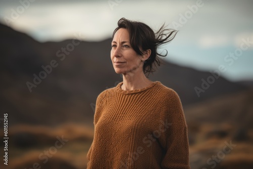 Portrait of a young beautiful woman with brown sweater posing outdoor.