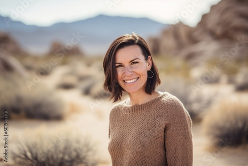 Portrait of a smiling woman in the middle of a desert landscape
