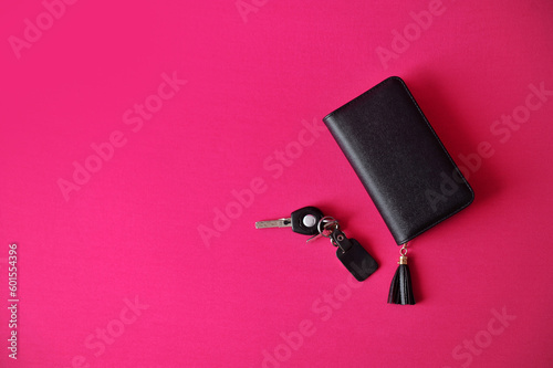 carteira feminina com chave de automovel  em fundo rosa photo