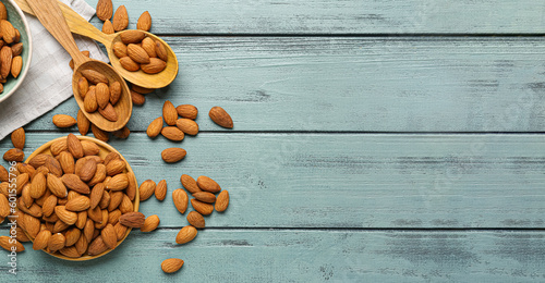 Composition with tasty almonds on wooden background with space for text, top view