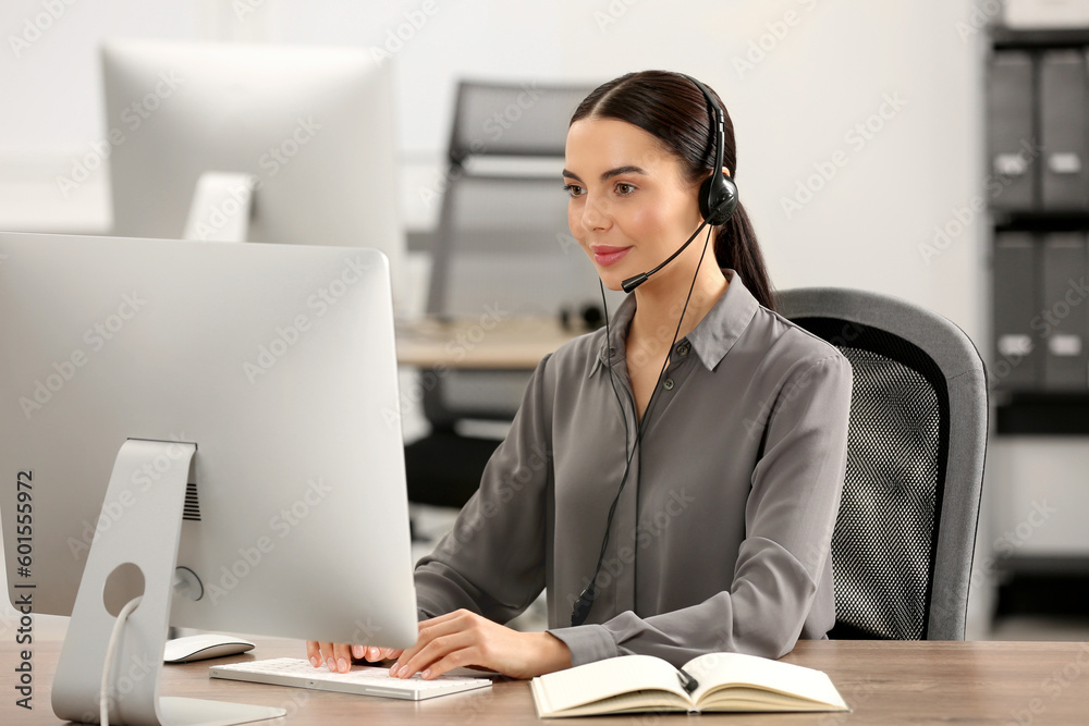Hotline operator with headset working on computer in office Hotline operator with headset working on computer in office